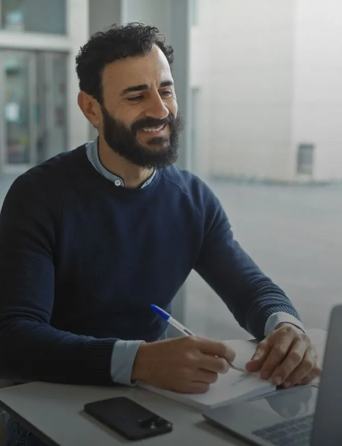 man work on office laptop holding pen